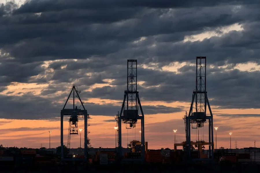 Grúas de contenedores en un puerto industrial al atardecer
