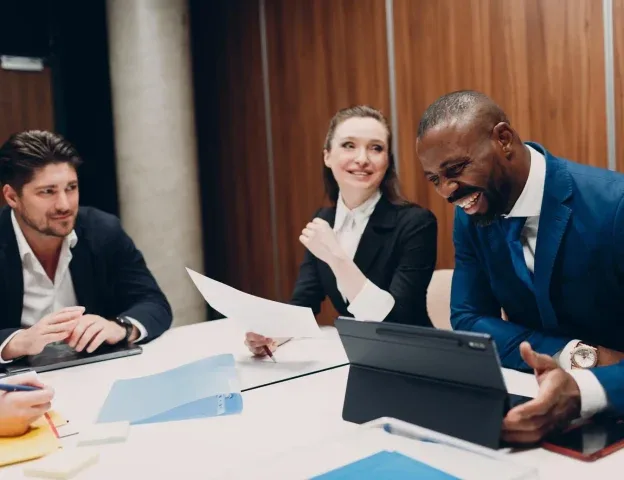 Un equipo de producto revisa una versión en conjunto alrededor de una mesa de reuniones