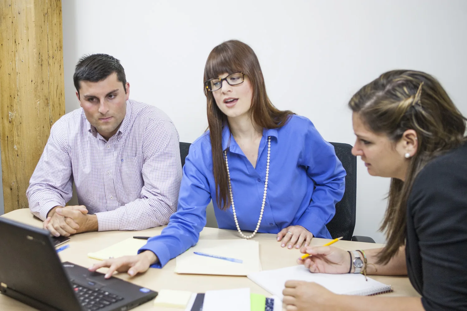 A localization team reviews translated web pages together on a laptop